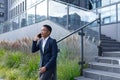 Angry and serious businesswoman talking on the phone outside the office, African American woman dressed in business clothes, Royalty Free Stock Photo