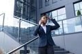 Angry and serious businesswoman talking on the phone outside the office, African American woman dressed in business clothes, Royalty Free Stock Photo