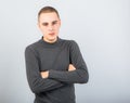 Angry serious young man thinking with folded hands  and looking on blue background. Closeup Royalty Free Stock Photo