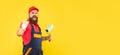 angry shouting bearded man renovator in work clothes hold paint roller and brush