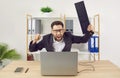 Angry shouting man working on workplace in office trying to destroy the monitor with his keyboard. Royalty Free Stock Photo