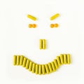 Angry smile made from many pills and capsules. wellness concept