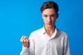 Angry stressed teen boy with clenched fist on blue background Royalty Free Stock Photo