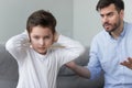 Angry strict father shouting screaming at little son at home