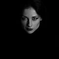 Angry strong look woman with smirking smiling posing isolated on dark shadow black background. Closeup portrait in deep low key