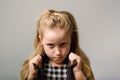 Angry and stubborn little slavic kid in leather black jacket on grey background