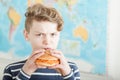 Angry teen boy trying to eat a carrot burger Royalty Free Stock Photo