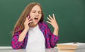angry teen girl speaking on mobile phone in high school at blackboard, conversation Royalty Free Stock Photo