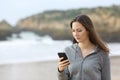 Angry teen reading phone message on the beach Royalty Free Stock Photo