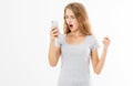 Angry teen woman in grey shirt shouting on smartphone over white background, bad news reading Royalty Free Stock Photo