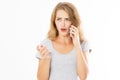 Angry teen woman in grey shirt shouting on smartphone over white background, bad news reading Royalty Free Stock Photo