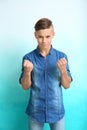 Angry teenage boy with clenched fists on color background Royalty Free Stock Photo