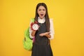 Angry teenager girl, upset and unhappy negative emotion. Back to school. Teenager school girl with backpack hold clock Royalty Free Stock Photo