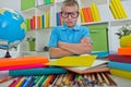 Angry and tired schoolboy studying with a pile of books on her d Royalty Free Stock Photo