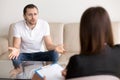 Angry troubled man complaining to female psychotherapist, talkin Royalty Free Stock Photo