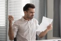 Angry unhappy businessman holding document, receiving bad news