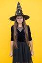 Angry and unhappy kid wear witch hat and glasses ready for enchantment on halloween, happy halloween