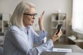 Angry unhappy senior business woman getting problems with smartphone Royalty Free Stock Photo