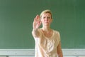 Angry and upset female teacher with stop gesture