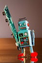 Tin toy robot carries computer circuit board, artificial intelligence concept Royalty Free Stock Photo