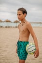 Angry wet boy holding volleyball ball on the beach Royalty Free Stock Photo