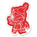 angry wolf quirky cartoon distressed sticker of a wearing santa hat