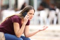 Angry woman calling on the phone in the street