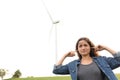 Angry woman covering ears listening wind mill noise