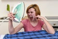 Angry woman or crazy busy housewife ironing shirt lazy at home k Royalty Free Stock Photo