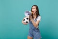 Angry woman football fan scream in megaphone, support favorite team with soccer ball isolated on blue turquoise Royalty Free Stock Photo
