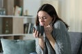 Angry woman getting cold holding coffee mug at home