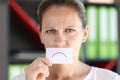 Angry woman holding card with negative emotion in front of her mouth. Royalty Free Stock Photo