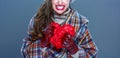 Angry woman isolated on cold blue background crushing red heart