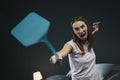 Angry woman killing mosquitoes with a fly swatter Royalty Free Stock Photo