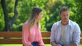 Angry woman looking at boyfriend sitting park bench, couple conflict, quarrel Royalty Free Stock Photo