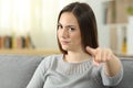 Angry woman pointing at camera at home