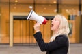 Angry woman protester yelling into a megaphone