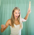 Angry woman with rolling-pin in hand Royalty Free Stock Photo