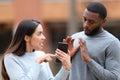 Angry woman scolding a man showing phone content