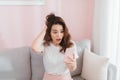 Angry woman screaming on the phone sitting on sofa in bright living room Royalty Free Stock Photo