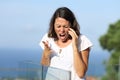 Angry woman shouting calling on phone in a balcony Royalty Free Stock Photo