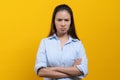 Woman standing crossed arms and stare at camera isolated on yellow background Royalty Free Stock Photo