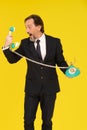 Angry, yelling middle aged business man in to old fashion telephone handset holding it in hands isolated on yellow Royalty Free Stock Photo