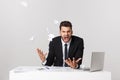 Angry young bearded man work at desk with laptop isolated over white background. Screaming tearing paper documents Royalty Free Stock Photo