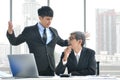 Angry young boss yelling at senior employee, business concept, Asian businessman Royalty Free Stock Photo