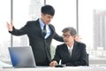 Angry young boss yelling at senior employee, business concept, Asian businessman Royalty Free Stock Photo