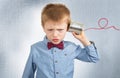 Angry young boy is listening with tin can telephone Royalty Free Stock Photo