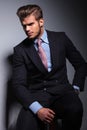 Angry young business man in classic suit and tie sitting Royalty Free Stock Photo