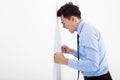 Angry young businessman leaning at the wall in office Royalty Free Stock Photo
