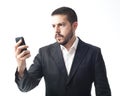 Angry young businessman looking mobile phone. Royalty Free Stock Photo